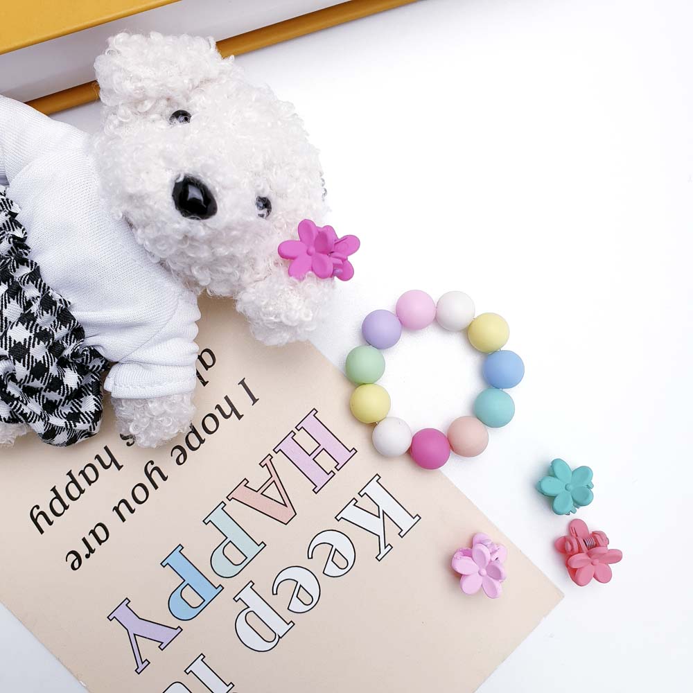 무광컬러구슬과 인형 등 다른부자재들이 컬러풀한 바닥에 놓여있습니다.