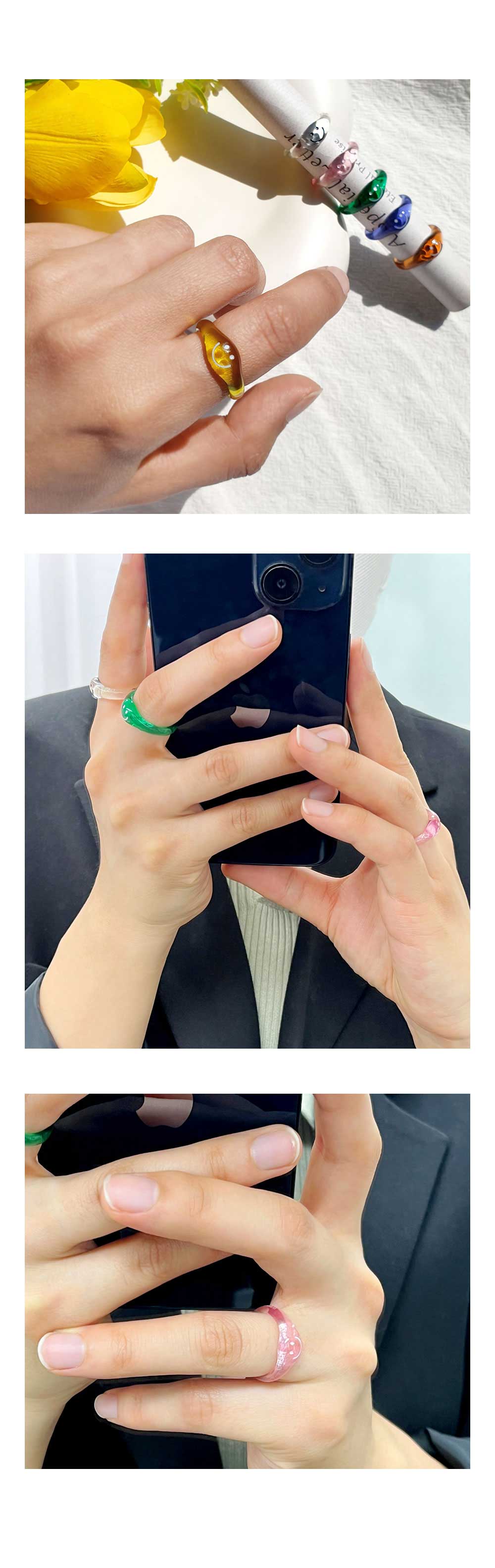 이 이미지는 반지는 직접 착용하여 분위기와 사이즈를 확인할 수 있는 이미지입니다. 첫번째 이미지는 코튼천에 노란장미와 영문종이를 원 기둥으로 말아 반지이 꽂은 배경에 왼손 검지에 엘로우 컬러를 착용하고 보여주고 있습니다. 두번째 이미지는 핸드폰을 사용하고 있는 양손 중 오른손 검지에는 투명, 중지에는 그린컬러를 착용하였고, 왼손 약지에 핑크컬러로 레이어드 한 모습입니다. 세번째 이미지는 두번째이미지에서 왼손 약지 부분을 클로즈업해서 자세히 볼 수 있게 한 이미지입니다.